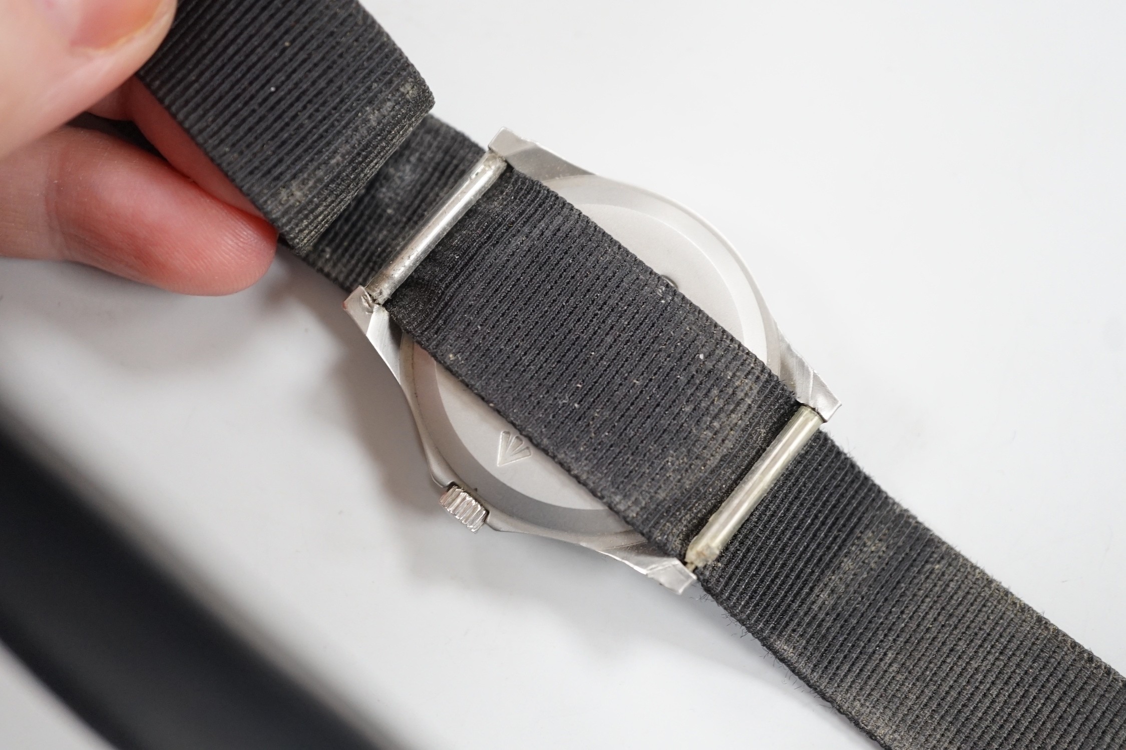 A steel? military CWC pilot's quartz wrist watch, with black Arabic dial, the case back with broad arrow and numbered, 0552/6645-99 over 5415317 over 45825 over 89, on a black fabric strap.
